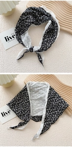 Detail of floral pattern and white lace trim on the triangular cotton linen scarf