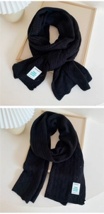 Detail of black hollow knit scarf featuring fine diamond texture and woven label