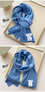 Detail of light blue knitted scarf showing fine texture and woven brand label