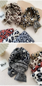 Detail of leopard jacquard knit scarf showing thick texture and ribbed hem in warm tones