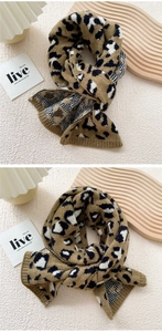 Detail of leopard print knitted scarf with ribbed edges and soft jacquard texture