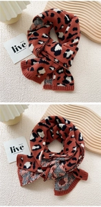 Macro detail of leopard print knit scarf in red and black soft winter fabric texture