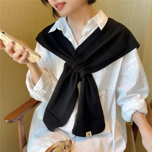 Chic black knitted shawl wrap with rib-knit texture and subtle woven brand label