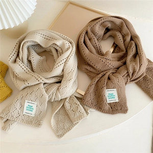 Beige and camel knit winter scarves with hollow crochet patterns and woven labels