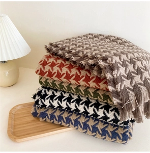 Detailed close-up of thick houndstooth knit scarves with tassels in multiple colorways