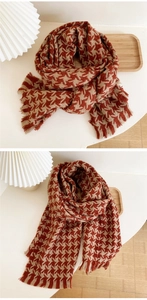 Detail of warm houndstooth knit scarf with tassels in brick red and beige colors