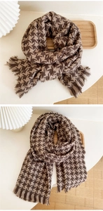 Close-up of thick houndstooth knit scarf with tassels in coffee and beige tones
