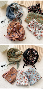 Detail of floral skinny silk scarves in multiple colors on a wooden display stand