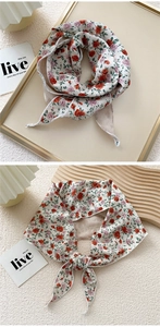 Detail of floral silk scarf showing red rose pattern and fine white stitched edges