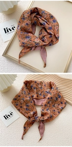 Detail of vintage floral skinny scarf in burnt orange with delicate small flower patterns