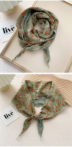 Detail of dark green floral silk scarf showing a knotted bow with orange rose pattern