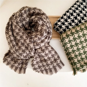 Houndstooth knit scarves in brown, black and green with tassels on a minimalist tray