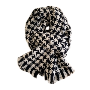 Cozy black and white houndstooth knit scarf with tassel fringe for winter warmth