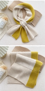 Detailed view of the thick ribbed knit texture on the two-tone cross-style winter scarf