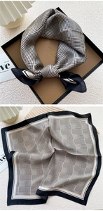 Macro detail of silk scarf with houndstooth and plaid patterns in a premium gift box