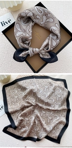 Detail of silk scarf with paisley pattern and elegant black border in a tray