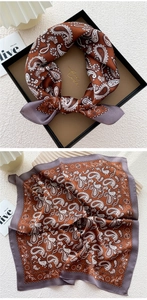 Detailed macro view of silk scarf with paisley patterns in rust red and lavender lilac