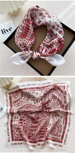 Detail of printed silk square scarf with geometric patterns in a black luxury gift box
