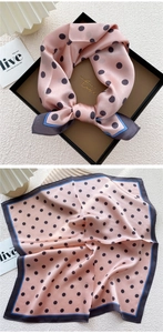Detailed view of pink polka dot silk scarf showing soft texture and premium contrast edges