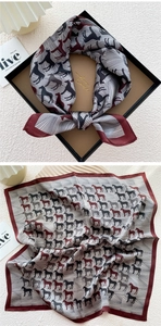 Detail of silk square scarf featuring burgundy borders and colorful horse silhouettes pattern