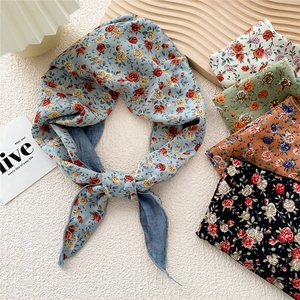 Floral print scarves in multiple colors displayed on a wooden tray for elegant styling