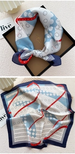 Artistic square silk scarf featuring navy blue borders and red ribbon pattern in a gift box