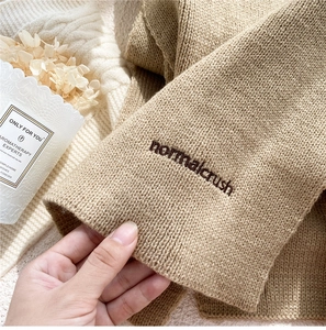 Detail shot of the khaki knitted scarf set featuring elegant brown letter embroidery