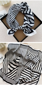 Detailed pattern of black and white geometric silk scarf in luxury gift box packaging