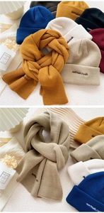 Detail of chunky cable-knit scarf and beanie set with normalcrush embroidery