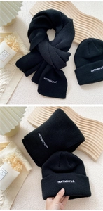 Detail of black knitted scarf and beanie set featuring white normalcrush embroidery