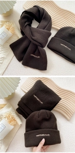 Close-up of dark brown knitted hat and scarf set with normalcrush embroidery