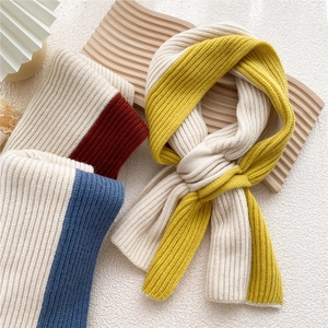 Crossed knit scarf in mustard, red and blue patchwork with textured ribbed knit patterns