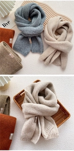 Detailed texture of thick knitted scarves in autumn colors with branded leather labels