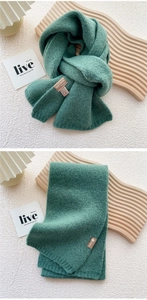 Detail of forest green knitted scarf showing soft wool-blend texture and vertical weave