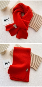 Close-up of red knitted scarf texture with ribbed pattern and brand care label