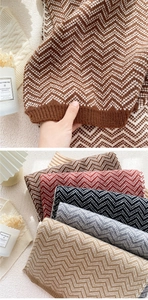 Detailed macro texture of zigzag knitted scarf with rich color palette and ribbed edges