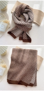 Detail of coffee and cream knit scarf with classic wave pattern and ribbed edge finish