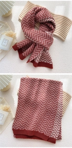 Detail of red and white chevron knit scarf featuring thick wool texture and ribbed edges
