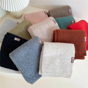 Minimalist knitted solid color scarves in multiple colors with a woven logo patch
