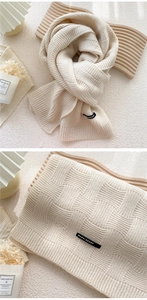 Détail macro de l'écharpe beige en tricot de panier et de l'étiquette tissée sur le tissu