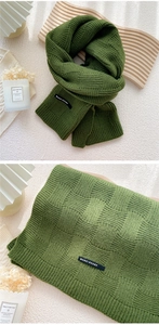 Vue détaillée de l'écharpe en maille vert olive à damier avec une étiquette tissée chic