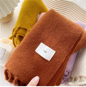Detailansicht der weichen Strickschal-Textur mit Fransen und verschiedenen Farben