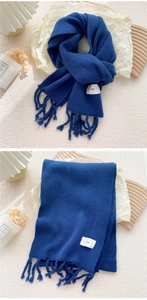 Nahaufnahme der dunkelblauen Strickschal-Struktur mit Fransen und egg-Markenetikett