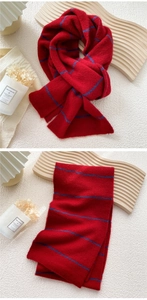 Detail shot of red striped knitted scarf texture with wool blend material on warm background