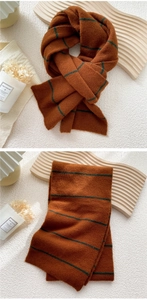 Detailed knit texture of the caramel brown and dark green striped winter scarf