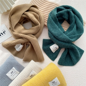 Five colors of thick knit winter scarves with vertical ribbed texture and handmade labels