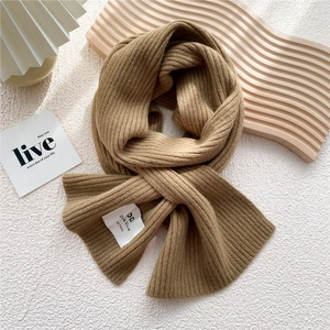 Detail of khaki brown ribbed knit scarf showing texture and brand label