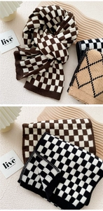 Close-up of thick knitted winter scarf featuring classic checkerboard and rhombus patterns