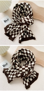 Detailed view of brown and white checkered knit scarf with ribbed edges for winter
