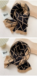 Detail view of knitted scarf with yellow and black diamond pattern and ribbed edges